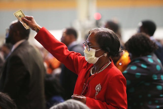 Una mujer sostiene su ofrenda durante un servicio del mediodía en la 115a Convocatoria COGIC en el Centro de Convenciones Renasant, el jueves 9 de noviembre de 2023, en el centro de Memphis, Tennessee.